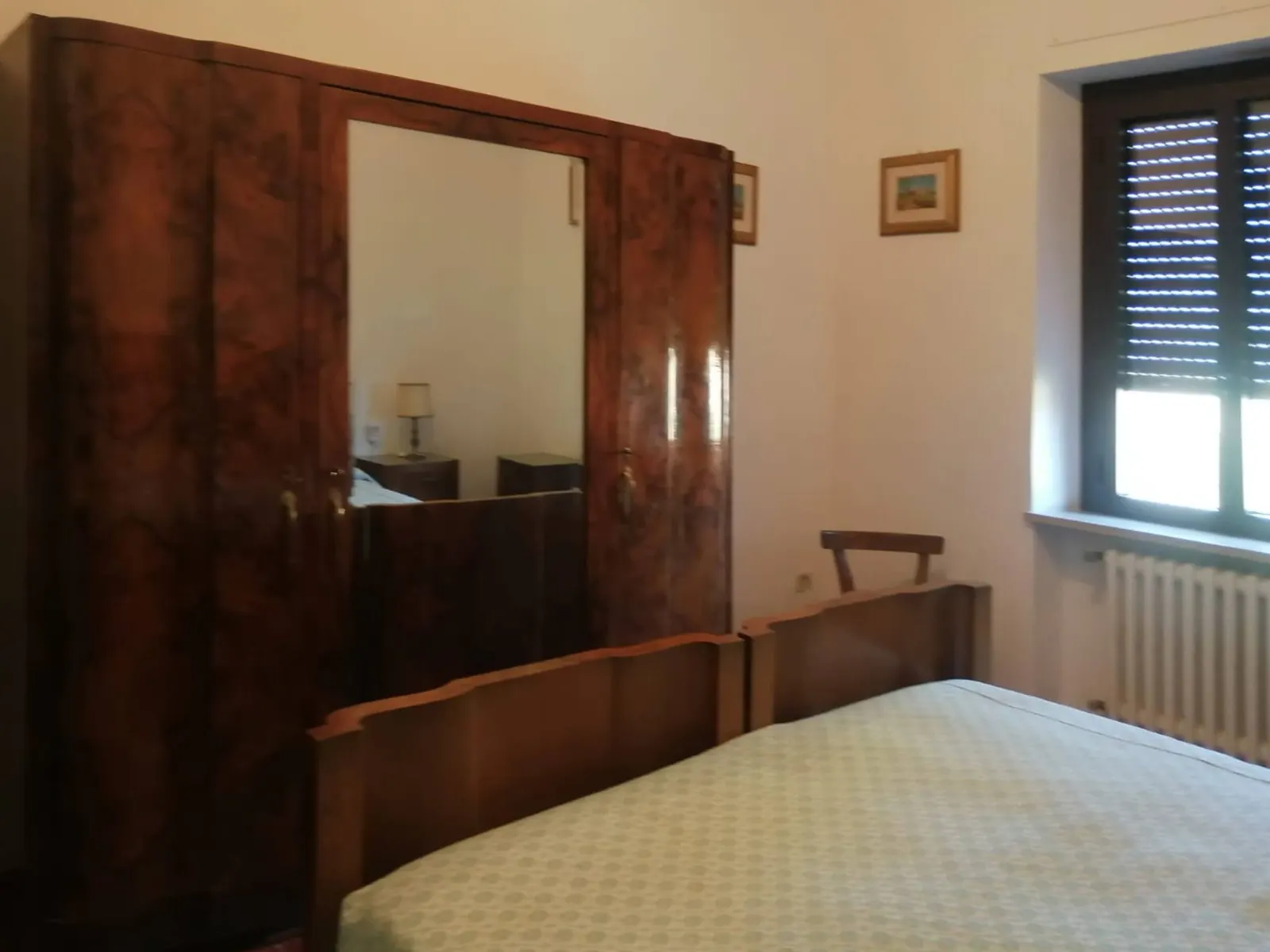 Bedroom with a wooden wardrobe and mirror