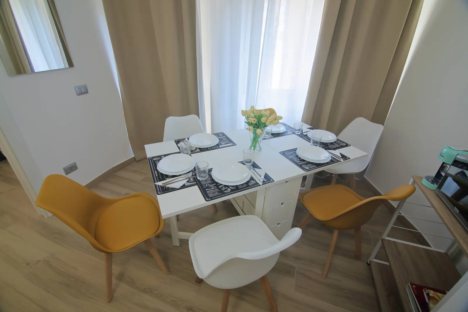 The dining table laid in front of the window