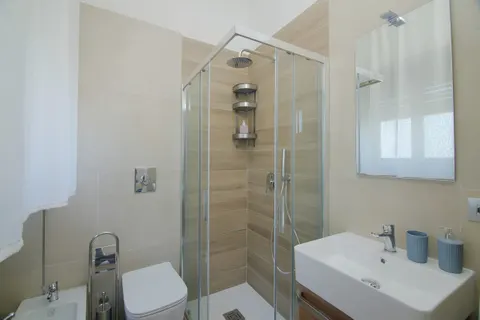 Bathroom with glass shower, washbasin and fittings