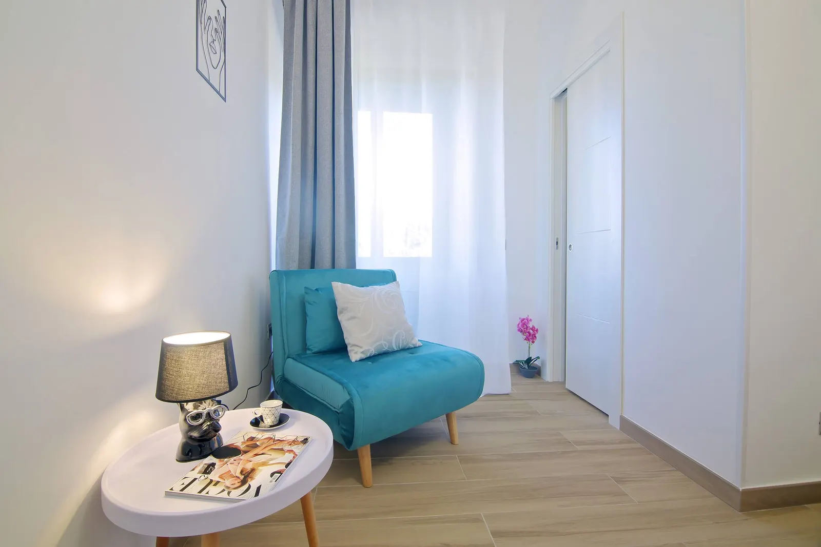 Blue armchair and side table in a corner of the bedroom