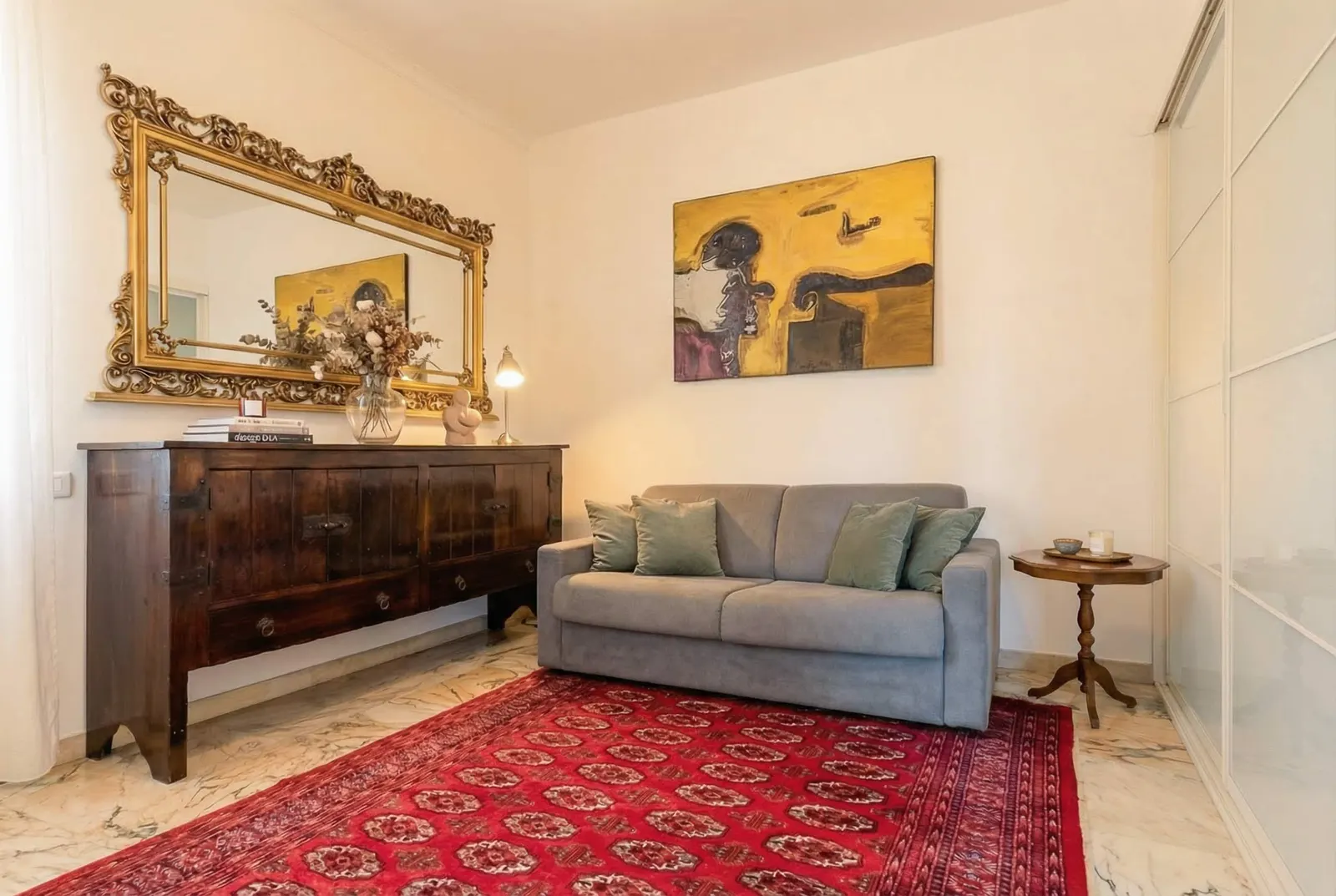 The suite's sitting area: sofa bed, gilded mirror and red rug