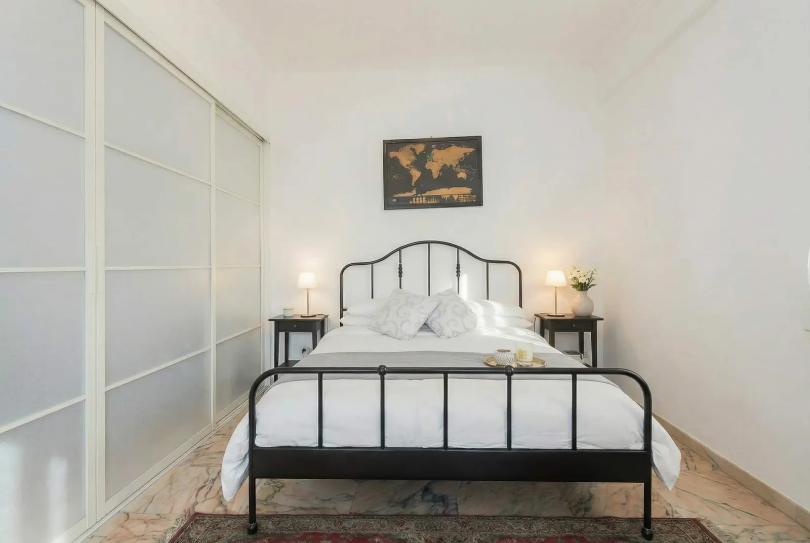 The suite's wrought-iron double bed beside the sliding partition