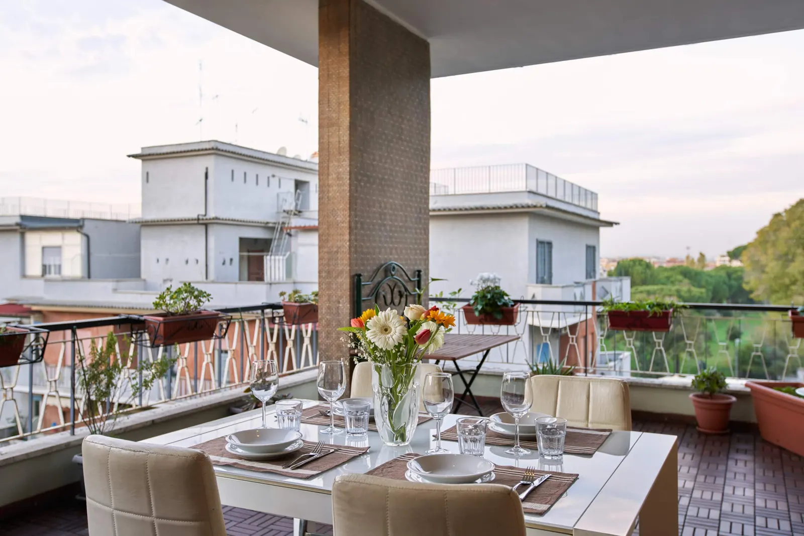 The covered terrace with a laid table and a view over the neighbourhood