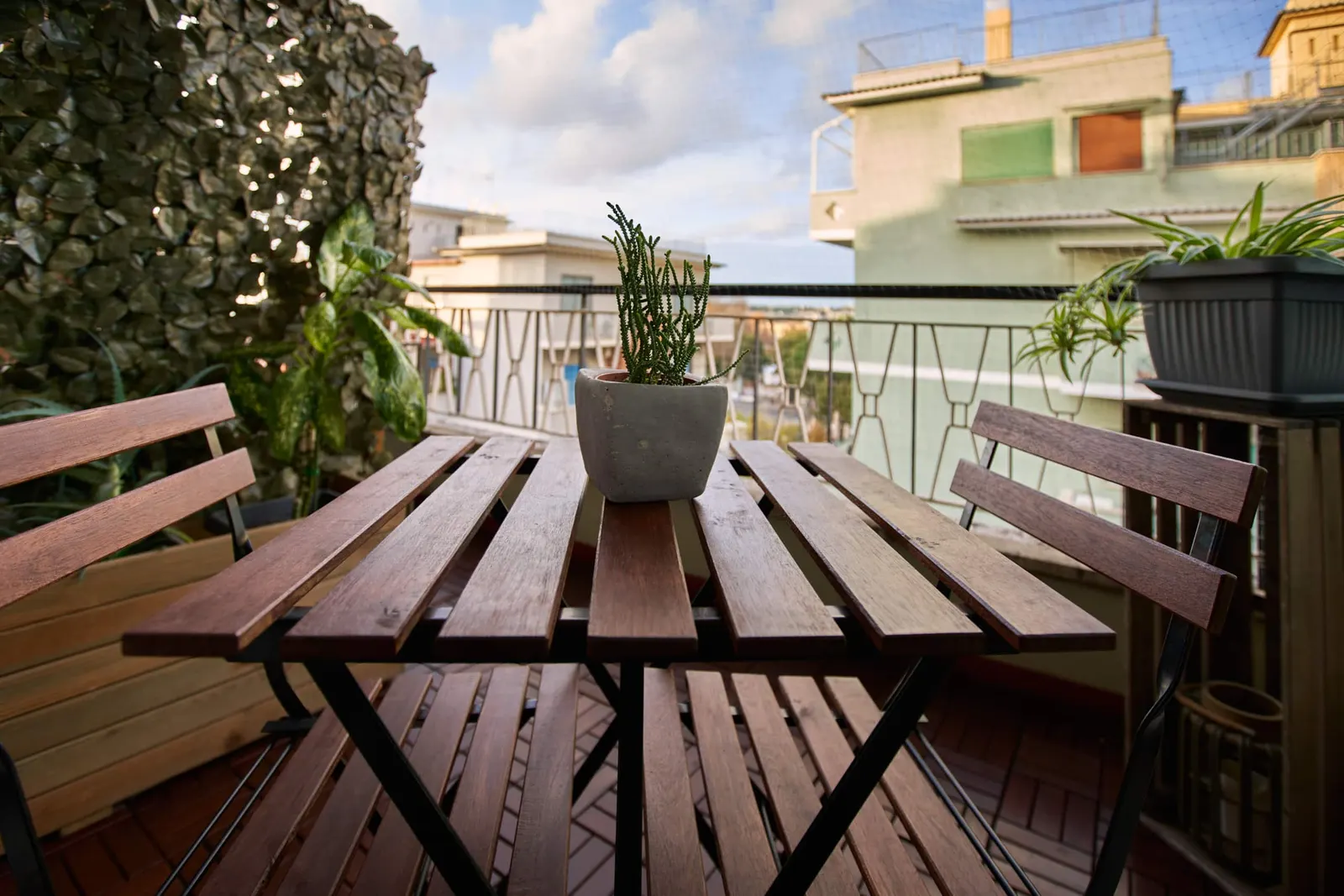 Wooden table and chairs on the balcony among the plants