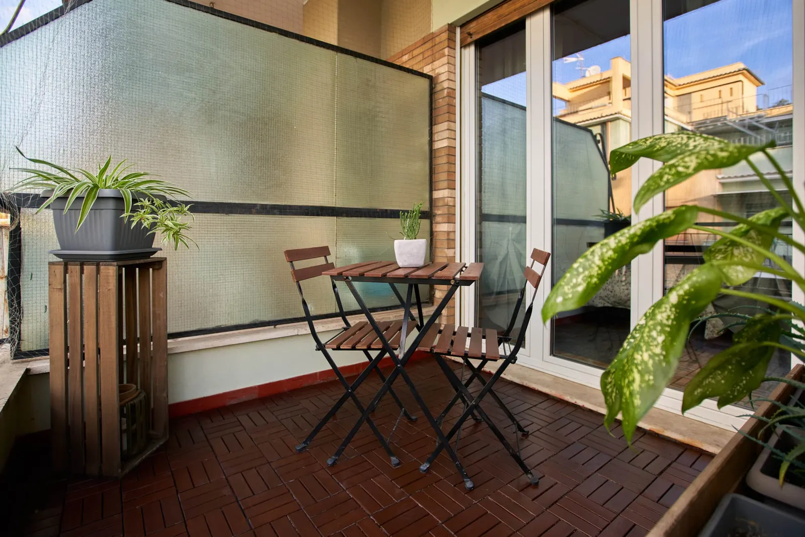 The balcony with a small table and folding chairs