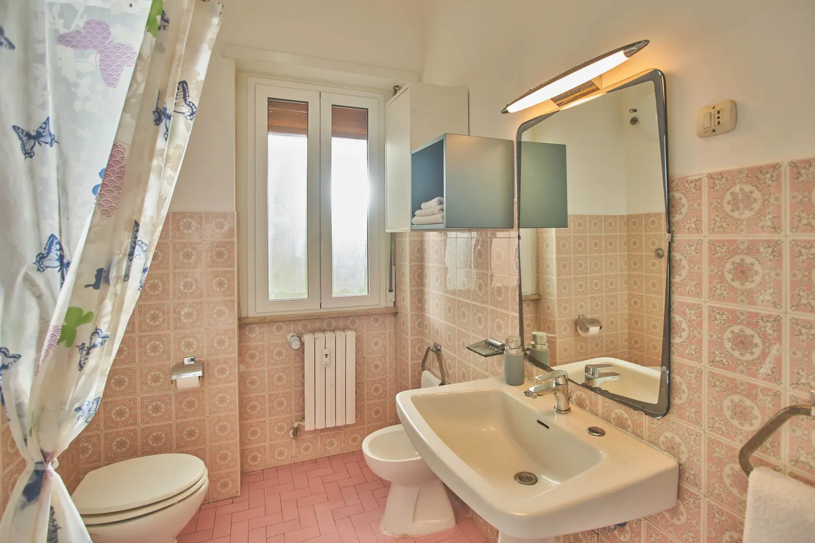 The large bathroom with washbasin, bidet and window