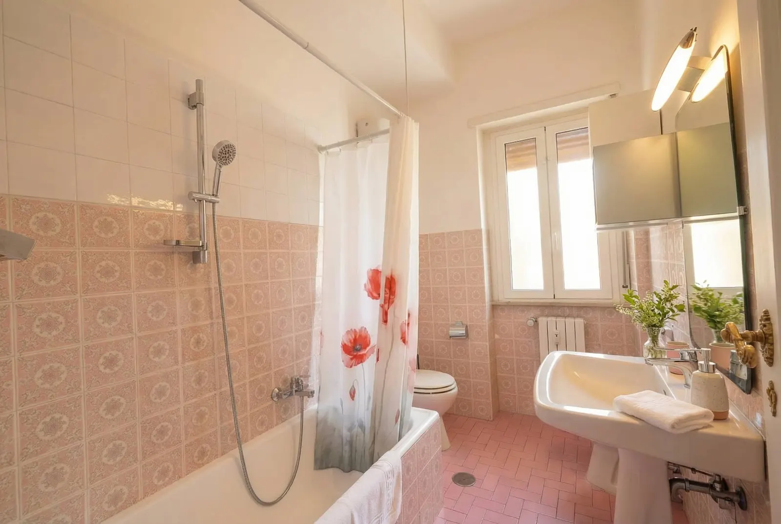 The bathtub with shower in the large bathroom